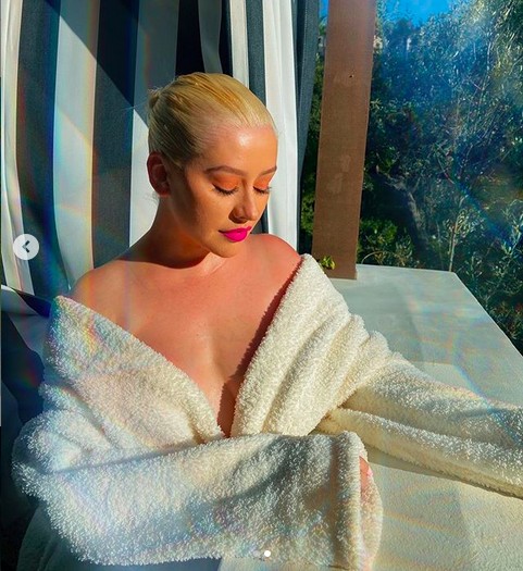 A cantora Christina Aguilera pegando um sol de roupão durante a quarentena (Foto: Instagram)