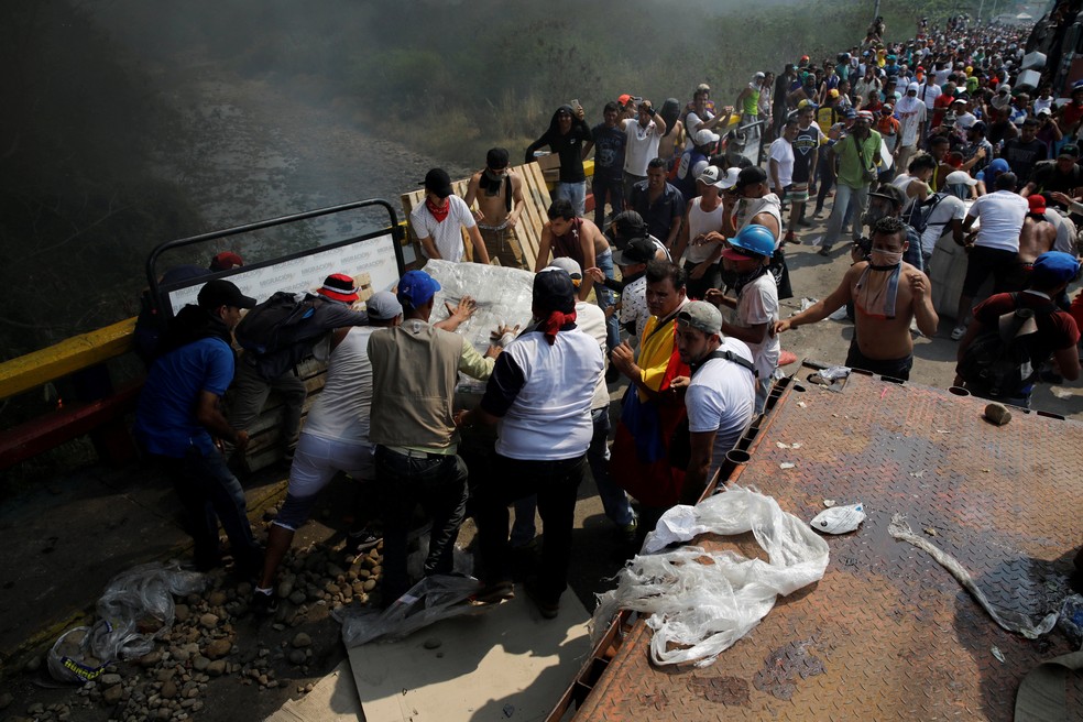 Manifestantes tentam recuperar os mantimentos após incêndio em Cúcuta — Foto: Marco Bello/Reuters