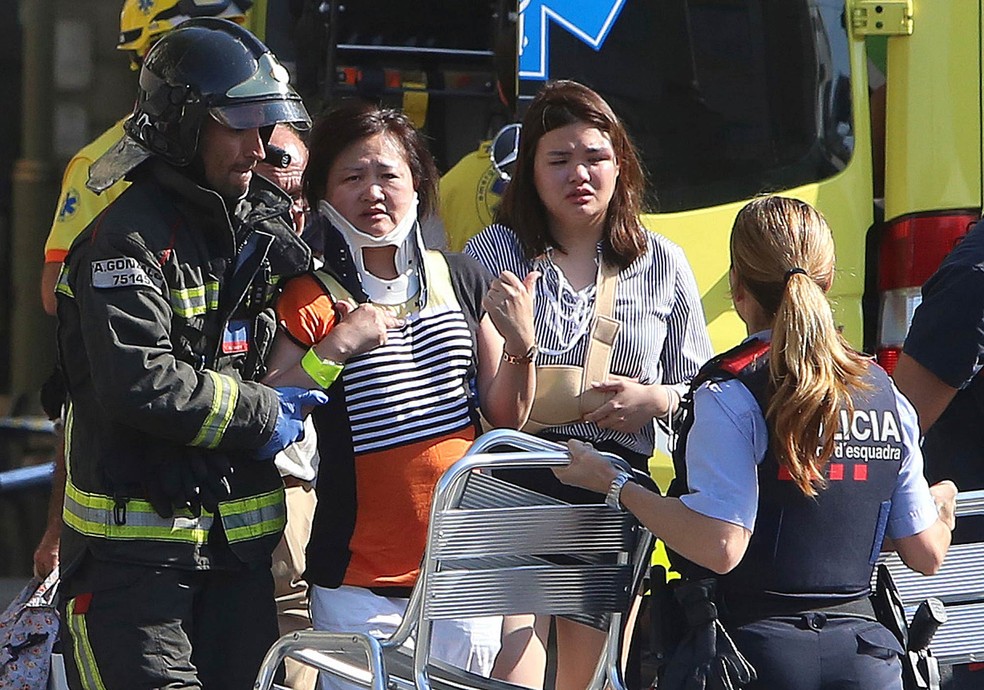 Mulheres feridas recebem tratamento após atentado com uma van que foi usada para atropelar diversas pessoas nas Ramblas de Barcelona (Foto: Oriol Duran/AP)