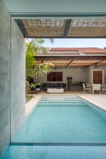 Neste projeto, assinado por Maurício Nóbrega, a casa vizinha foi comprada para dar lugar a uma área de lazer completa, com piscina, sauna, espaço de estar e churrasqueira