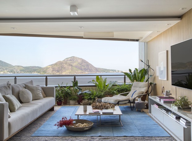 Sala de piso de concreto e piscina com vista para o mar com fundo