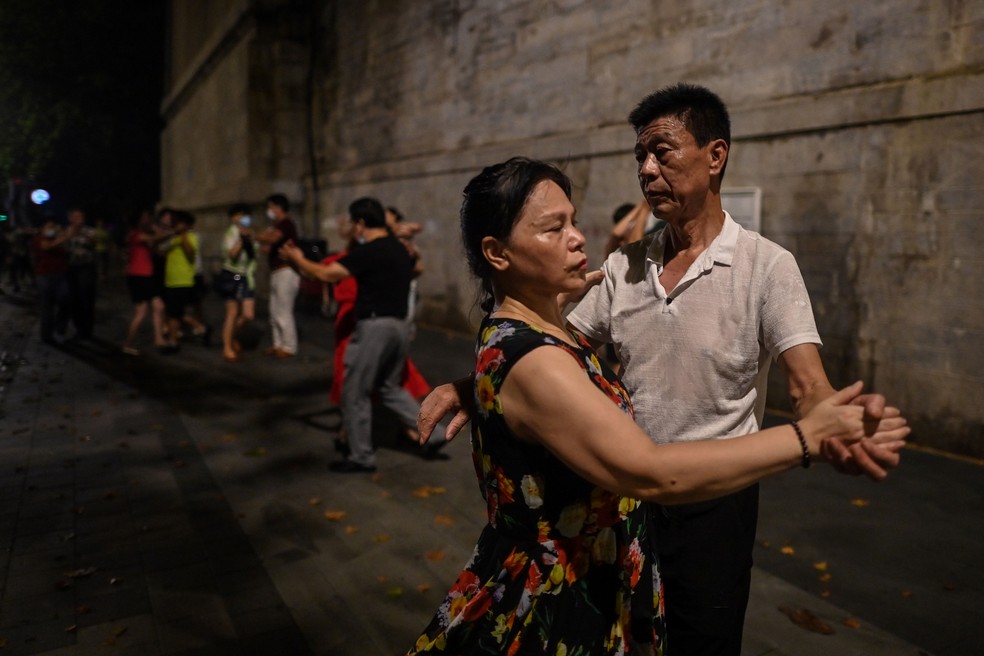 Casais dançam perto do rio Yangtze em Wuhan, na província de Hubei, no centro da China, no última quarta-feira (5) — Foto: Hector Retamal/AFP