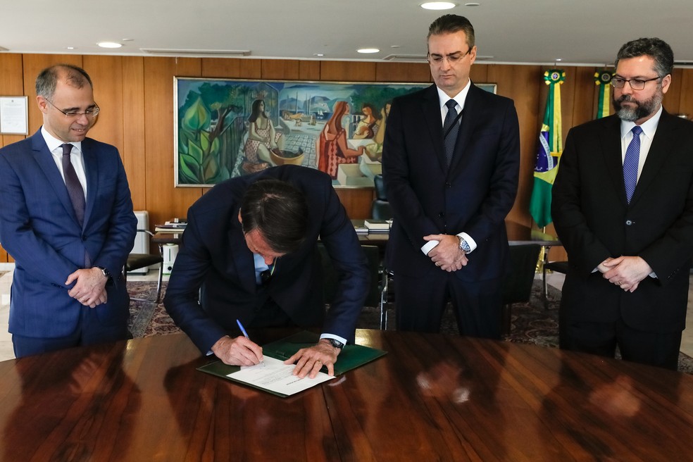 Bolsonaro assina posse do novo diretor-geral da PF, Rolando de Souza (segundo da direita para a esquerda), junto com os ministros da Justiça, André Mendonça, e das Relações Exteriores, Ernesto Araújo. — Foto: Isac Nóbrega/PR
