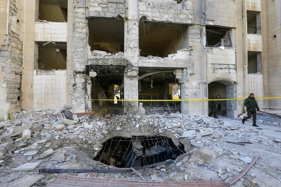Membros das forças de segurança sírias inspecionam um prédio danificado em um ataque de míssil israelense relatado em Damasco