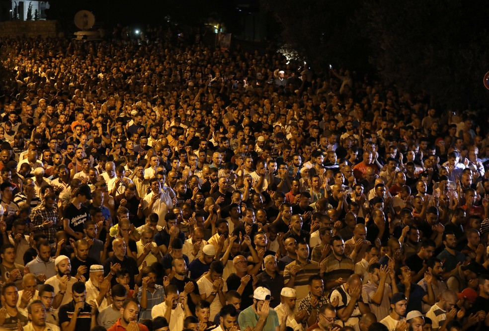 Palestinos rezam nesta segunda-feira (24) do lado de fora da Esplanada das Mesquitas em Jerusalém (Foto: REUTERS/Ammar Awad)