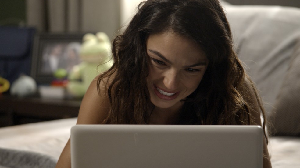 Ela está bem feliz falando com Zeca pela internet ... (Foto: TV Globo)