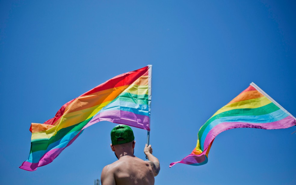 Homem agita bandeira do orgulho LGBT durante parada em Tel Aviv, Israel, na sexta (12) — Foto: Ariel Schalit/AP