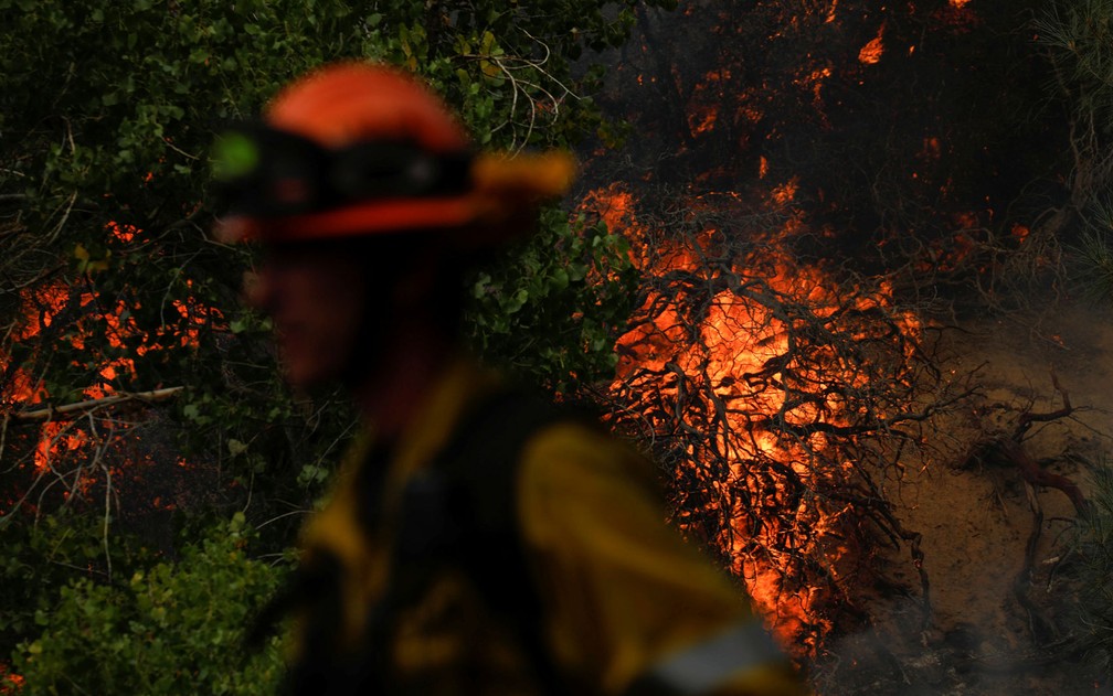 Um bombeiro monitora foco do Incêndio do Lago, em área montanhosa da Floresta Nacional Angeles, ao norte de Los Angeles, na Califórnia, na quinta-feira (13) — Foto: Reuters/Patrick T. Fallon 