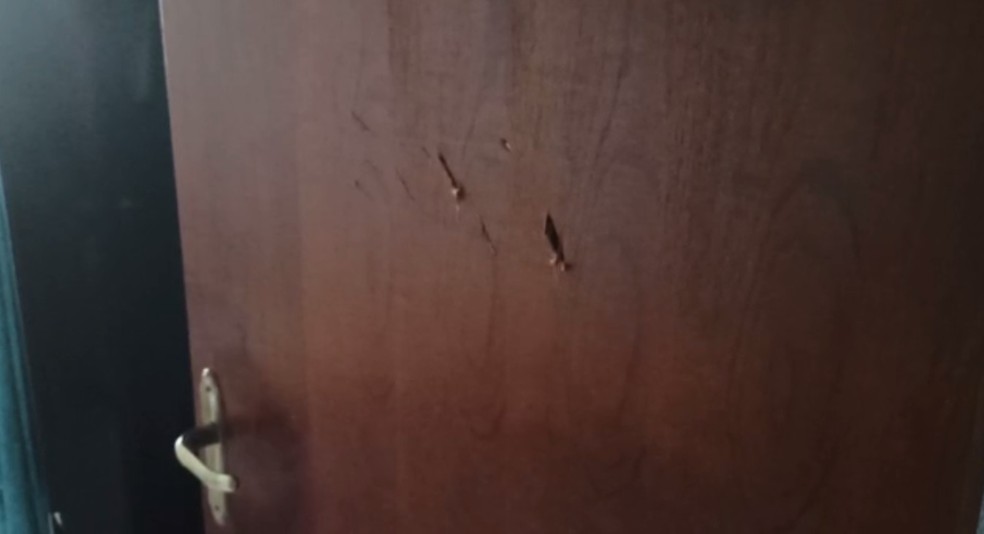 Marcas de facadas foram encontradas pela PM na porta do quarto onde o adolescente se escondeu, em Londrina — Foto: Divulgação/PM