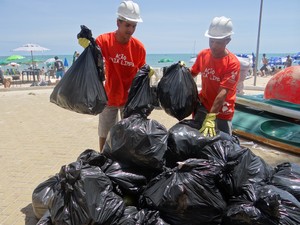 Universitários recolhem lixo em praia de Maceió.  (Foto: Natália Souza/ G1)