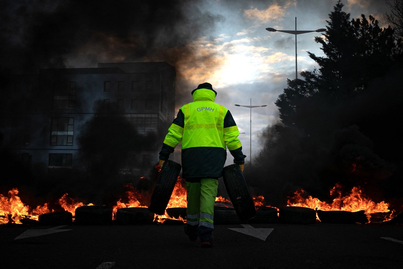 Funcionários do porto de Le Havre atearam fogo na entrada da cidade contra a reforma da previdência francesa — Foto: LOU BENOIST/AFP