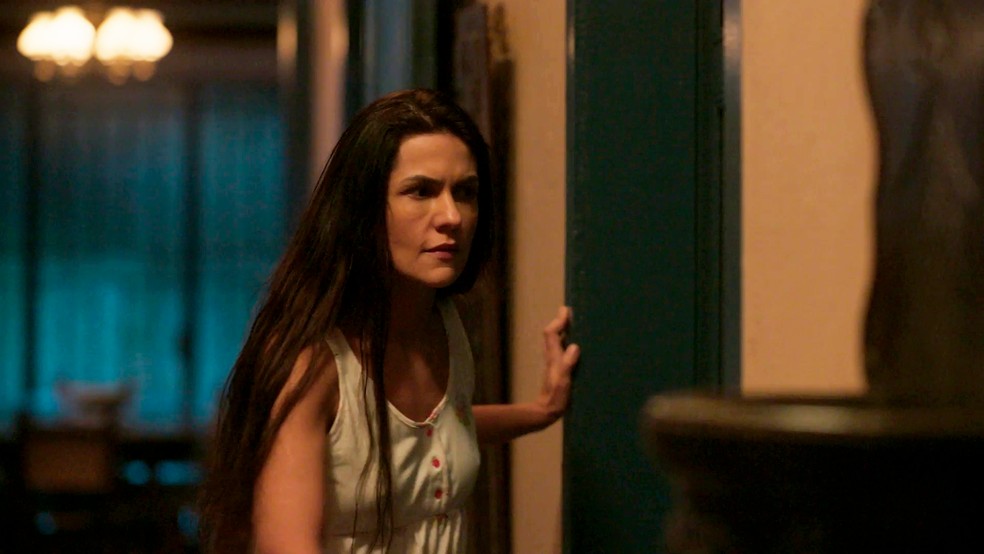 Zefa (Paula Barbosa) vai estranhar o barulho e ficará atrás da porta — Foto: Globo