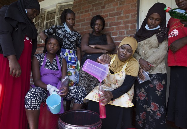 Fatima Kasisi, no centro, ensina outras mulheres de sua comunidade no Zimbábue a fazer seu próprio detergente em casa (Foto: Wilfred Kajese/Anadolu Agency via Getty Images)