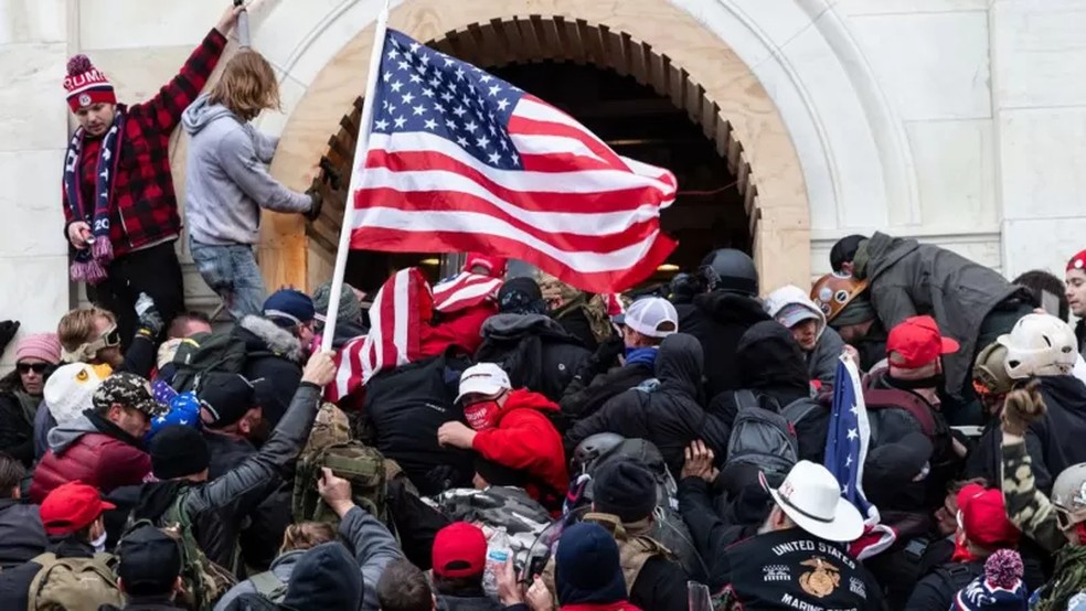 Apoiadores de Trump forçam passagem pela porta principal do Congresso dos EUA em 6 de janeiro de 2021 — Foto: Getty Images/Via BBC