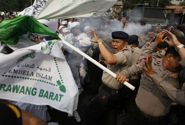 Manifestantes e policiais se enfrentam em frente da Embaixada dos EUA na Indonésia, em Jacarta, nesta segunda-feira (17) (Foto: AP)