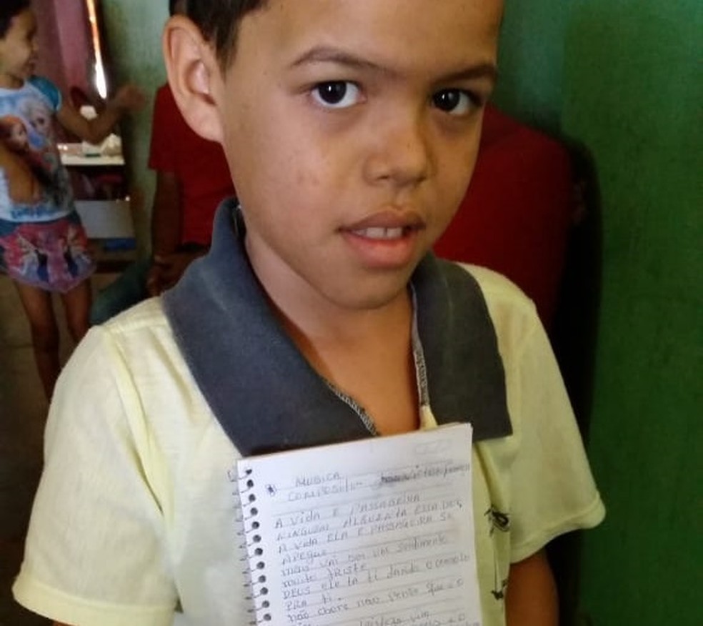 JoÃ£o Vitor escreveu a letra da mÃºsica em um caderno com ajuda da tia dele (Foto: FablÃ­cia FranÃ§a/Arquivo Pessoal)