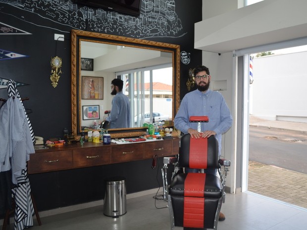 Uma cadeira de barbeiro em uma barbearia com um espelho na parede
