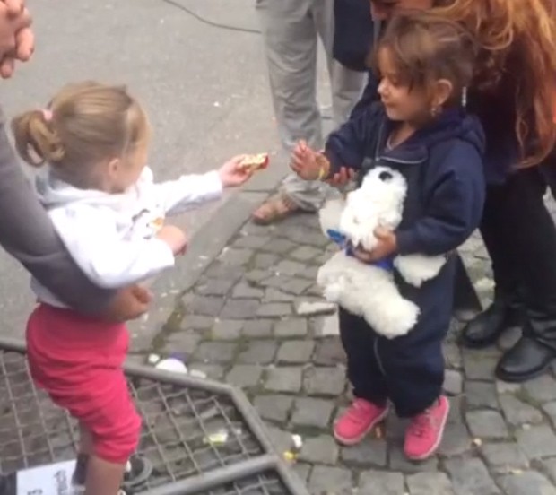 Menina alemã oferece doces à pequena refugiada durante crise migratória na Europa (Foto: Reprodução Vine)
