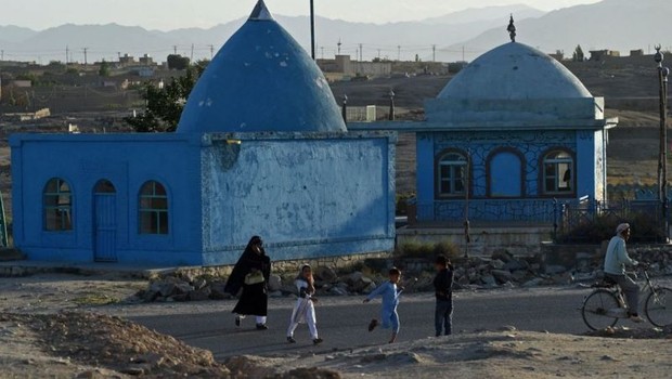 Pessoas passam por um santuário em Ghazni, cidade histórica do Afeganistão (Foto: Getty Images via BBC)