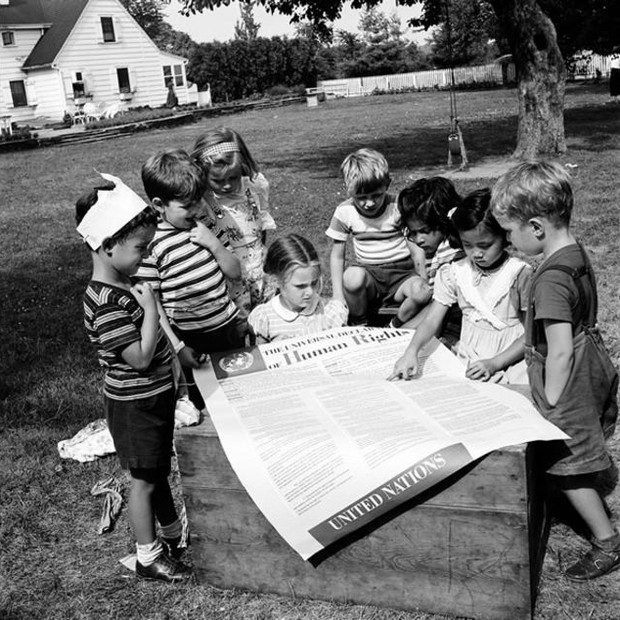 Crianças com um exemplar gigante da Declaração; documento tem 30 artigos do "ideal comum a ser atingido por todos os povos e todas as nações" (Foto: ONU)