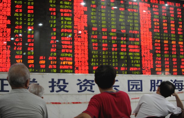 Investidores observam painel eletrônico de movimentação do mercado financeiro na Bolsa de Xangai , na China (Foto: Getty Images)
