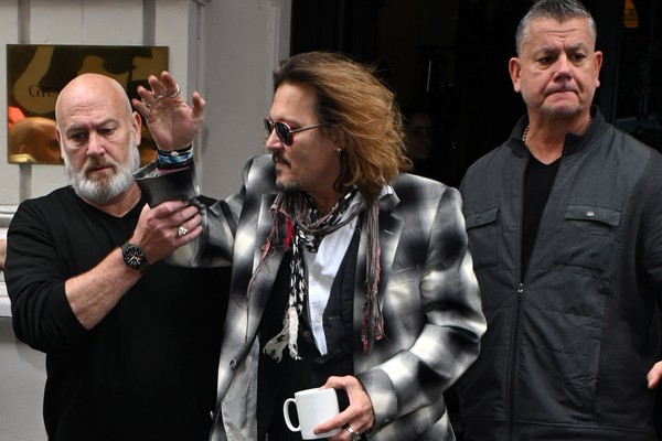O ator Johnny Depp deixando um hotel na cidade inglesa de Birmingham na companhia de seguranças (Foto: Getty Images)