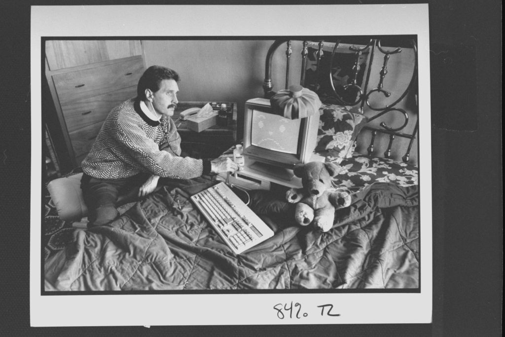 Computer analyst John McAfee holding stethoscope to IBM type computer sitting on bed w. ice bag on top, illustrating computer virus which McAfee is able to eradicate; at home.  (Photo by John Storey/The LIFE Images Collection via Getty Images/Getty Images (Foto: The LIFE Images Collection via G)