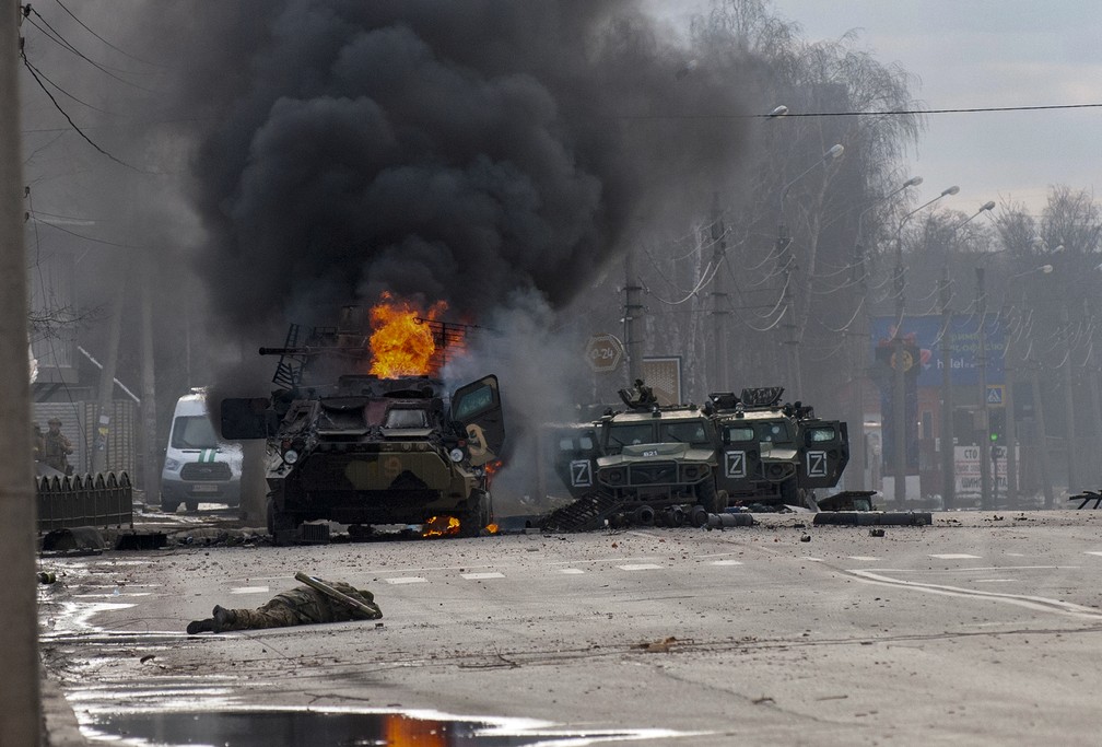 Um transportador de pessoal blindado russo queima em meio a veículos utilitários leves danificados e abandonados depois de lutar em Kharkiv, Ucrânia. — Foto: Marienko Andrew/AP Photo