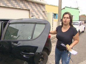 Moradora mostra carro atingido por tiro durante ação dos criminosos em Piracaia (Foto: Reprodução/TV Vanguarda)