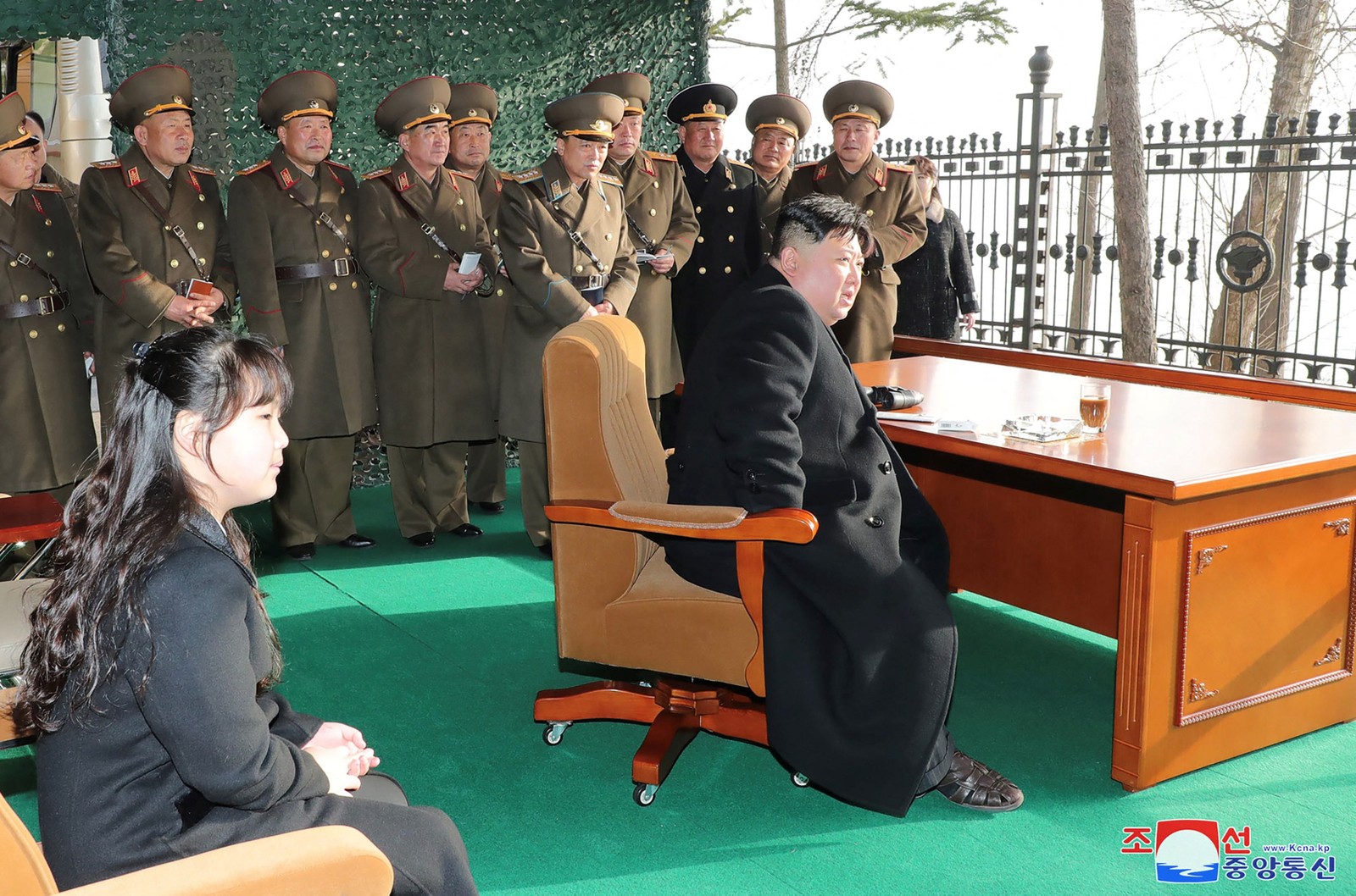 O líder da Coreia do Norte, Kim Jong Un (sentado à mesa), e sua filha (à esquerda) observam, em 9 de março de 2023, treinamento da Unidade de Artilharia de Marte, responsável por importantes missões operacionais da Frente Ocidental do Exército do Povo Coreano — Foto: Agência Central de Notícias da Coreia do Norte (KCNA) via AFP