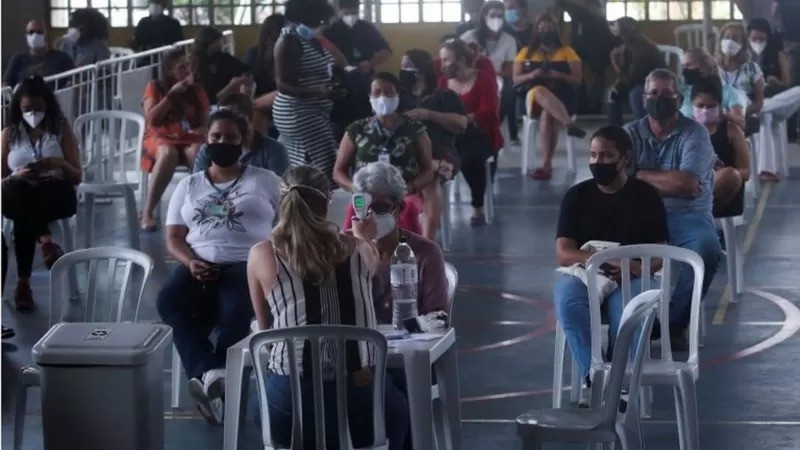Atendimento a pacientes com sintomas de covid-19 ou gripe no Rio; muitos profissionais da saúde fazem jornada dupla ou tripla (Foto: BBC via Reuters)
