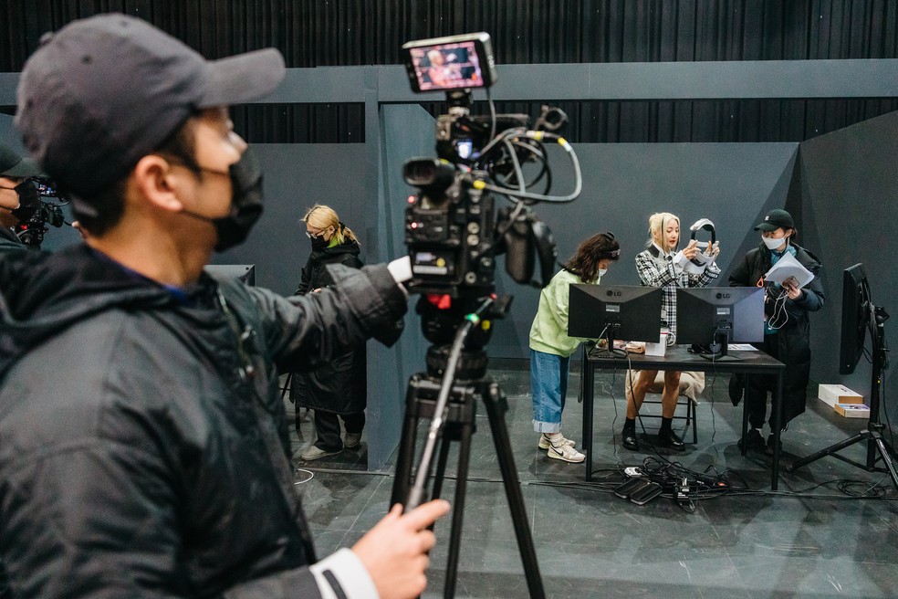 A cantora Bada, outra participante do programa “Girl's Re:verse”, show de K-pop do metaverso, se prepara para colocar um fone de ouvido e entrar no “W”, o universo virtual do show — Foto: Jun Michael Park/The New York Times