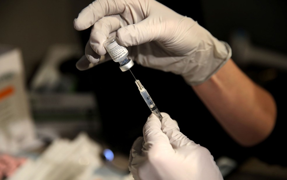 A farmacêutica Larren Suh prepara uma dose da vacina contra Covid-19 da Pfizer-BioNTech  noMassachusetts General Hospital, em Boston, na quarta-feira (16) — Foto: Craig F. Walker/Pool via Reuters