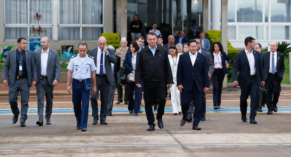 O presidente da República, Jair Bolsonaro, caminha ao lado do vice-presidente, Hamilton Mourão, que assumirá o Planalto durante a viagem presidencial — Foto: Alan Santos/PR