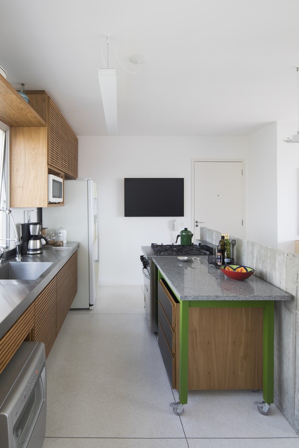 A cozinha integrada com a sala tem espaços bem aproveitados pela marcenaria planejada 