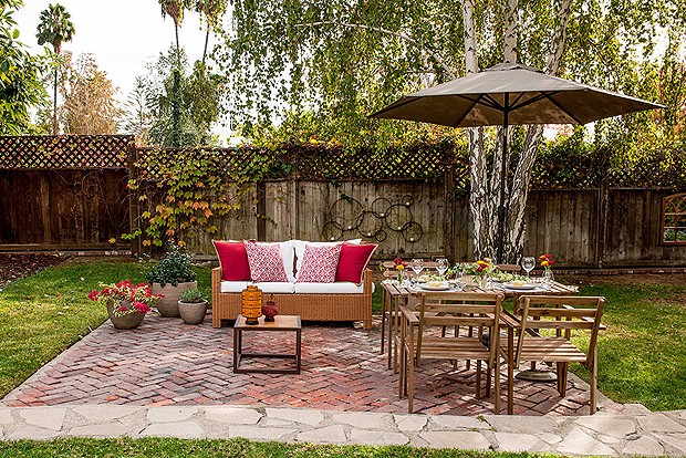 A mesa e o pequeno sofá são um verdadeiro convite para tomar um café na área externa, repleta de plantas e árvores. Um sonho! (Foto: Divulgação)