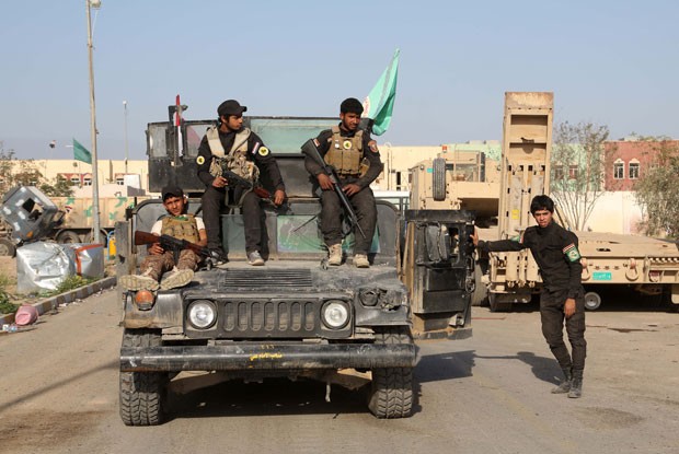 Jovens milicianos são vistos antes de combates com o Estado Islâmico em Tikrit neste domingo (15) (Foto: Khalid Mohammed/AP)
