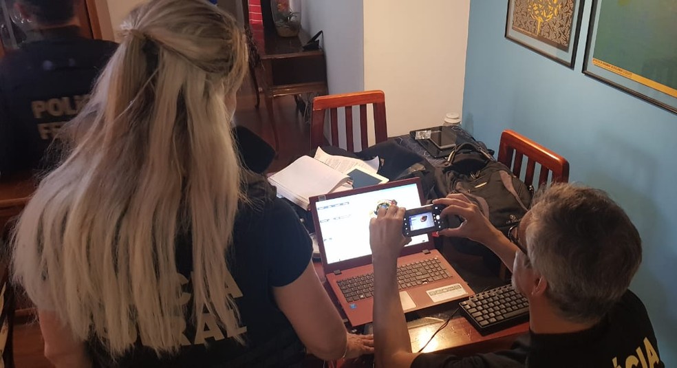 Agentes analisam computador durante 5ª fase da operação Luz na Infância — Foto: Polícia Federal/Divulgação