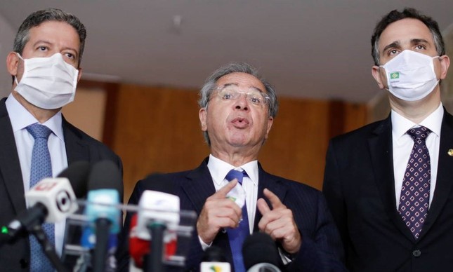 O ministro da Economia, Paulo Guedes, entre os presidentes da Câmara e do Senado, Arthur Lira (PP-AL) e Rodrigo Pachego (DEM-MG)