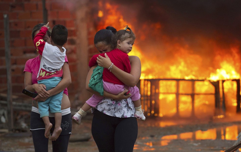 Moradores de Pinheirinho caminham para longe do fogo enquanto tentam resistir à reintegração de posse (Foto: Roosevelt Cassio/Reuters)