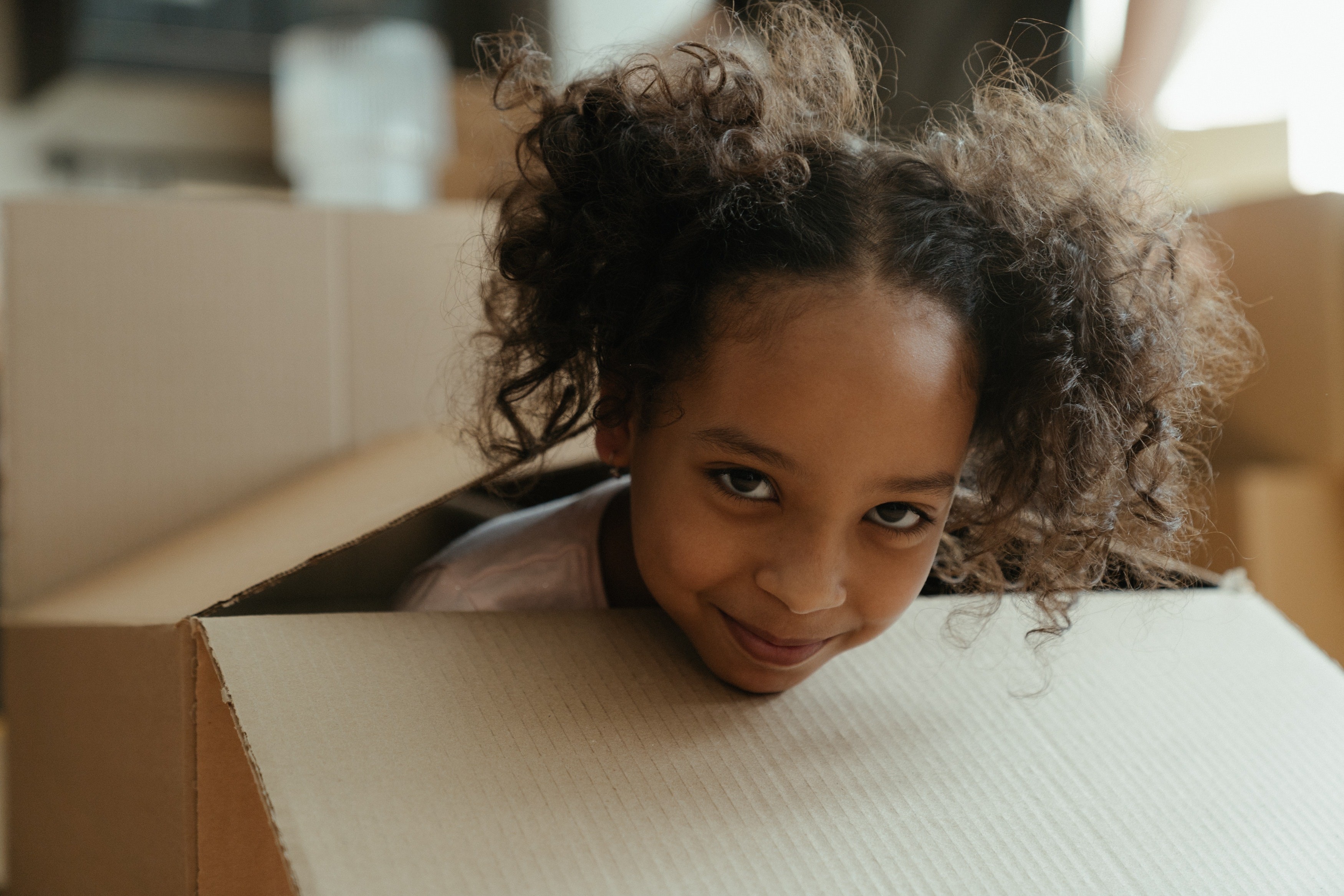 Menina brincando em caixa de papelão (Foto:  cottonbro/Pexels)