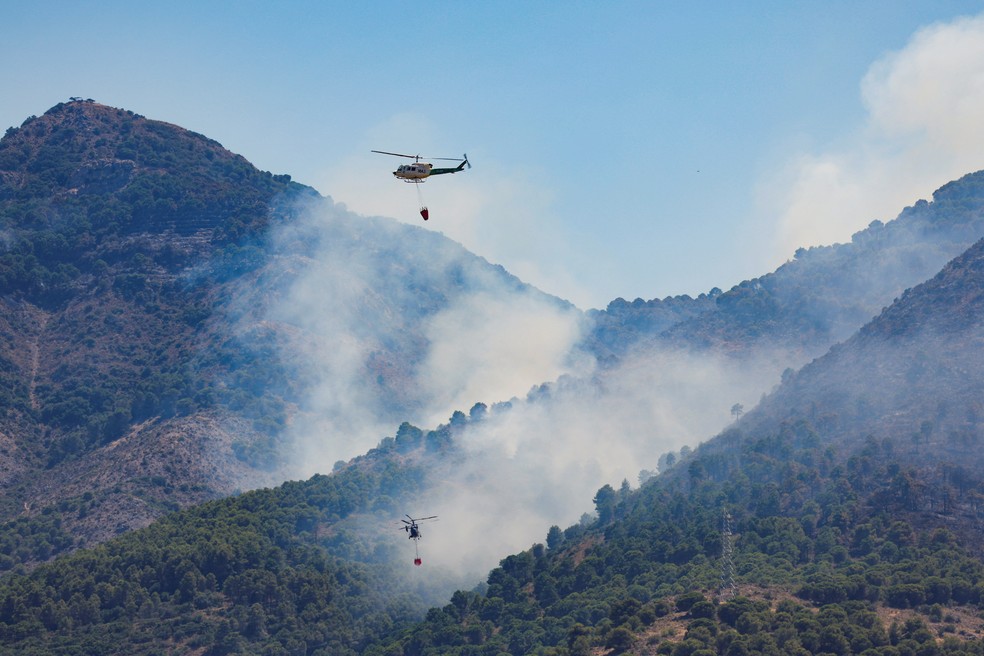 Helicóptero tenta apagar fogo no parque nacional de Monfrague, em Caceres, na Espanha, durante a segunda onda de calor do ano. — Foto: Isabel Infantes/Reuters
