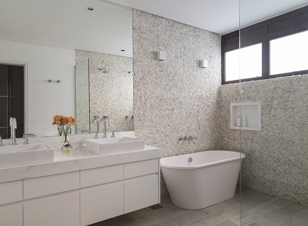 BANHEIRO DO CASAL | O destaque do banheiro é o revestimento de pedras White Bali Seixo da Pasinato. Banheira Brisa da Sabbia (Foto: Evelyn Muller / Divulgação)