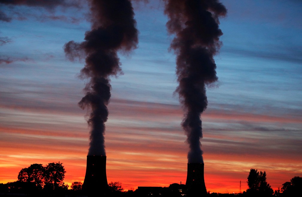 Torres de resfriamento da usina nuclear de Golfech em pôr-do-sol à beira de rio entre Agen e Tolouse, na França (Foto: Regis Duvignau/Reuters)