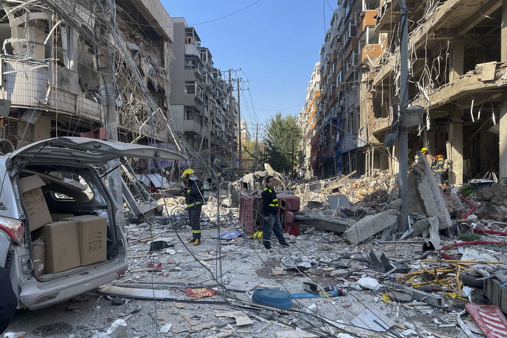 Policiais e bombeiros trabalham no local da explosão de uma churrascaria em Shenyang, no nordeste da China, que deixou mortos e feridos e imóveis danificados em rua movimentada na capital da província de Liaoning em 21 de outubro de 2021 — Foto: Cai Xiangxin/Xinhua via AP