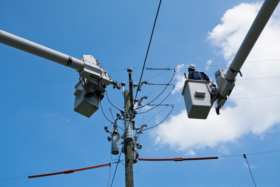 Funcionários consertam linhas de distribuição de energia após passagem de furação Irene na Virgínia