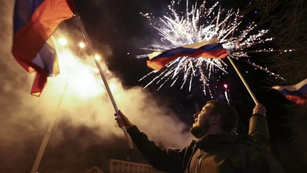 Moradores da cidade de Donetsk comemoram o reconhecimento formal da independência da República de Donetsk por Putin (Foto: Getty Images via BBC)