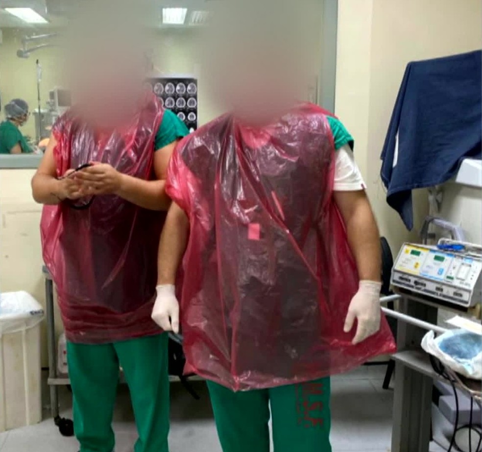Médicos vestem sacos plásticos como proteção no atendimento aos pacientes no Hospital Salgado Filho — Foto: Reprodução/TV Globo
