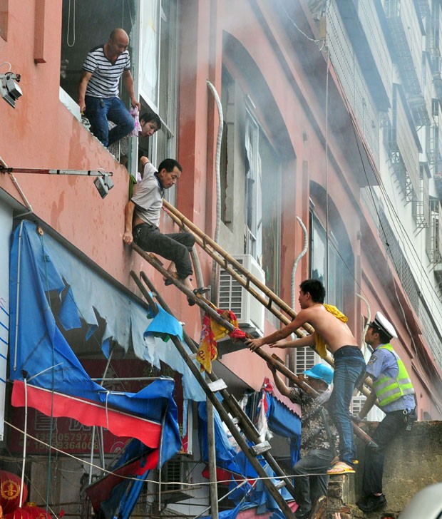Pessoas são retiradas de prédio em chamas na China; incêndio atingiu creche (Foto: China Daily/Reuters)