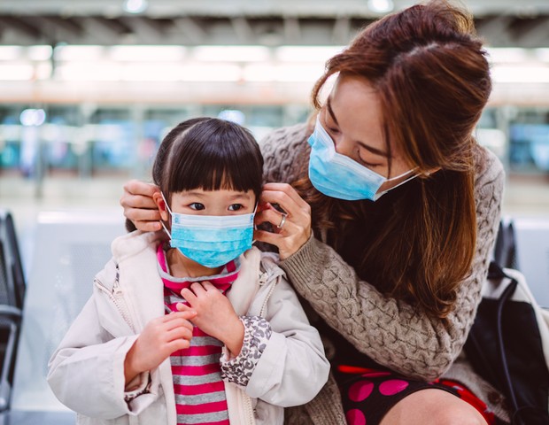Mãe colocando máscara em criança (Foto: Getty Images)